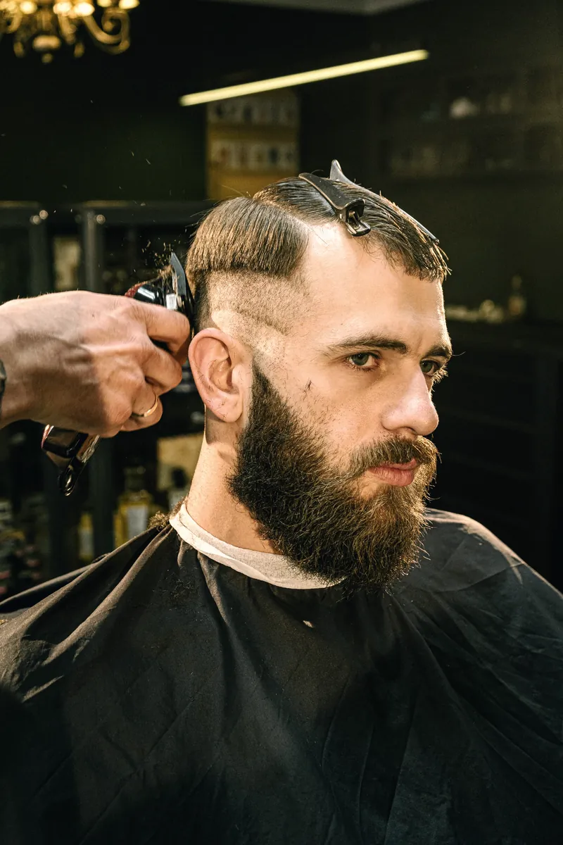 Client with a full beard mid-fade
