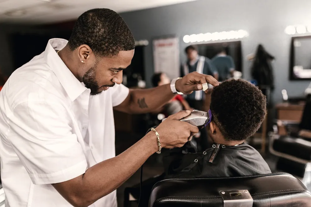 Barber cutting a young client's hair