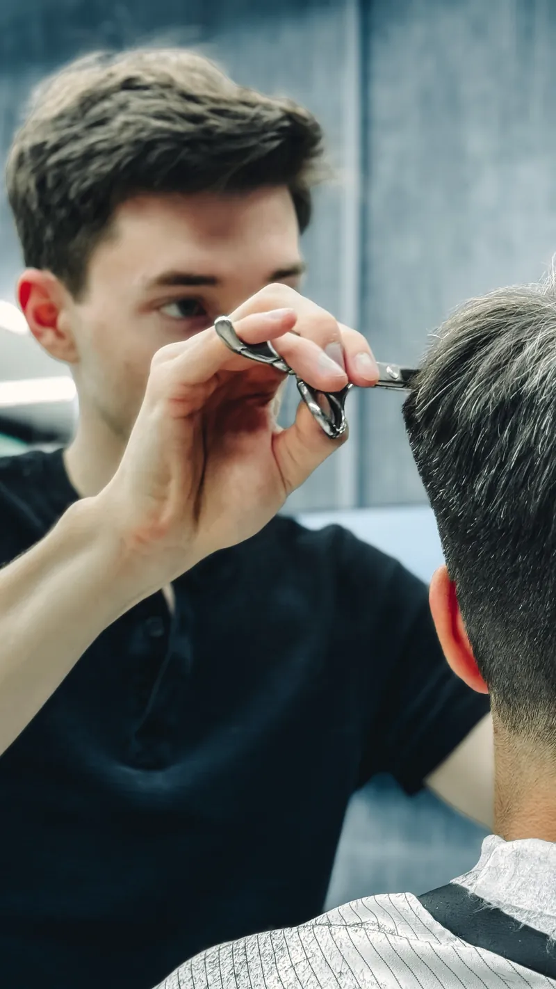 Barber cutting with scissors