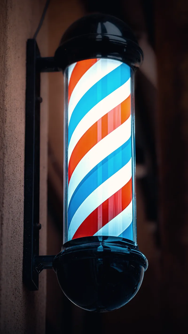 Illuminated barber pole at night